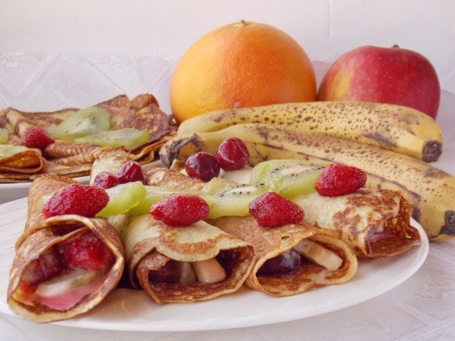 Выкладываем завернутые блинчики с фруктами на тарелку украсив фруктами