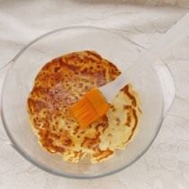 На дно формы укладываем целый блинчик, промасливаем его