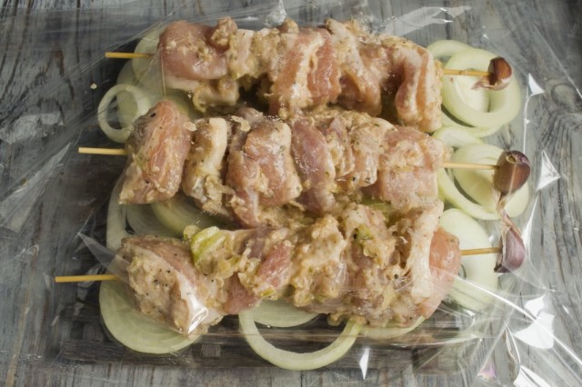 На лук выкладываем маринованную свинину на шпажках