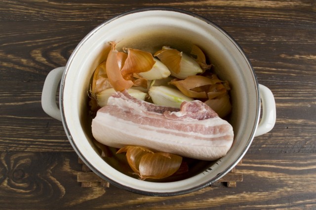 Кладём в кастрюлю кусок свиной грудинки