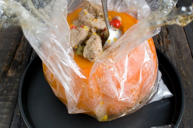 Перекладываем начинку из мяса с рисом и овощами в тыкву и ставим тушиться в духовку