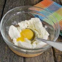 Разбиваем в миску с творогом куриное яйцо