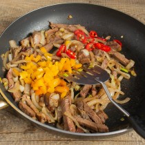 Нарезаем сладкий болгарский перец и чили, прогреваем с мясом на среднем огне Нарезаем сладкий болгарский перец и чили, прогреваем с мясом на среднем огне