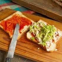 На ломтик хлеба кладём нарезанное мясо, затем щедрую щепоть капусты