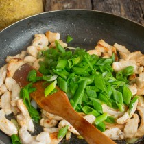 Высыпаем зелёный лук на готовую курицу, прогреваем буквально минуту