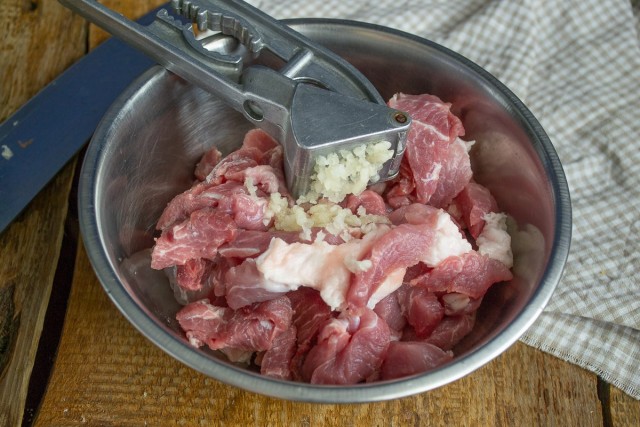 Кладём нарезанное мясо в миску, добавляем чеснок Кладём нарезанное мясо в миску, добавляем чеснок
