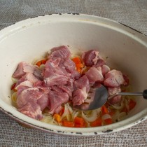 Добавляем свинину в жаровню. На сильном огне обжариваем мясо несколько минут 