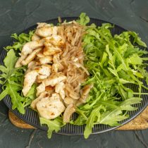 Кладём полоску маринованного лука рядом с курицей