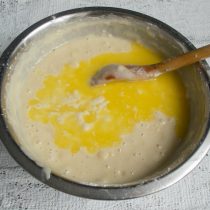Вливаем сливочное масло в тесто, тщательно перемешиваем