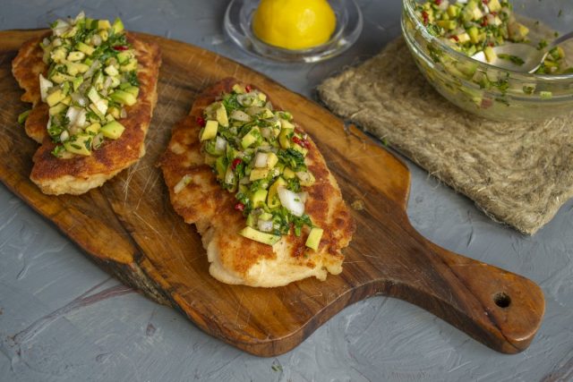 Выкладываем мясо на тарелку, сверху кладём несколько ложек зелёной сальсы