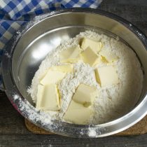 Сливочное масло режем кубиками, добавляем к муке