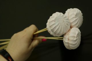 Первыми накалываем на палочки самые крупные элементы композиции, в нашем случае — зефир