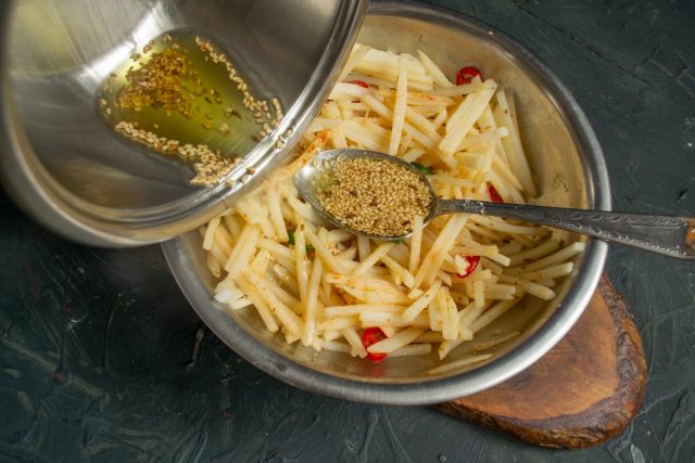 Раскалённое масло с кунжутом выливаем на картошку