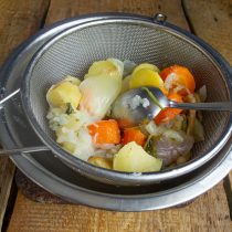 Достаём курицу из кастрюли, процеживаем бульон, перекладываем овощи в сито Достаём курицу из кастрюли, процеживаем бульон, перекладываем овощи в сито