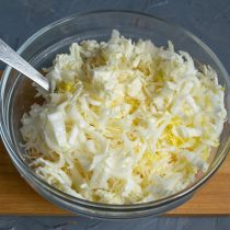 Шинкуем листики пекинской капусты, посыпаем щепоткой соли, слегка разминаем руками и добавляем в салатницу