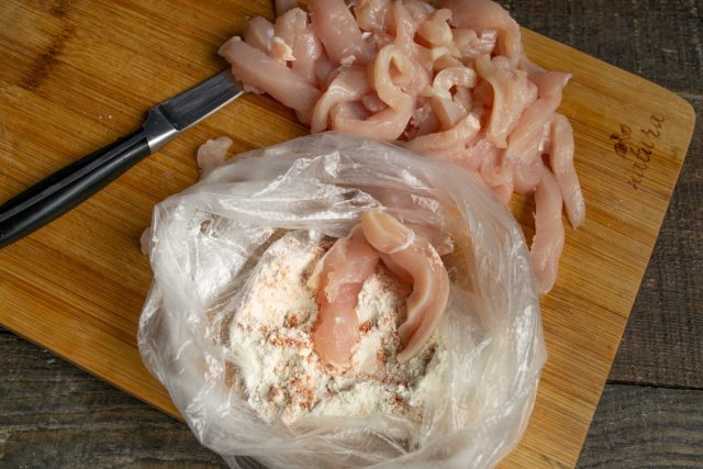 Кладём нарезанное мясо в пакет с панировкой, завязываем и встряхиваем