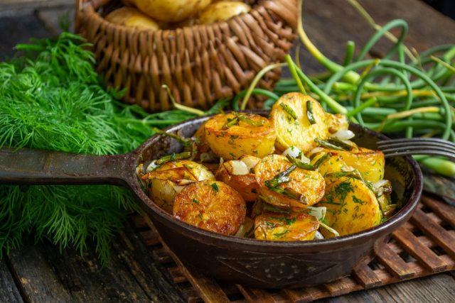 Молодая картошка, жаренная на сковороде с чесночными стрелками Молодая картошка, жаренная на сковороде с чесночными стрелками