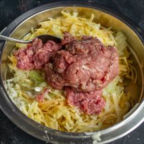 Посыпаем овощи мукой, затем добавляем фарш из говядины