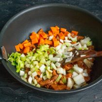 Добавляем лук и чеснок, обжариваем овощи с мясом примерно 10 минут