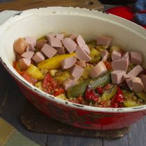 Через полчаса добавляем порезанные кубиками копченые сардельки