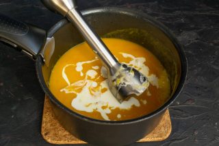 Наливаем сливки, солим по вкусу, перемешиваем и нагреваем на тихом огне почти до кипения