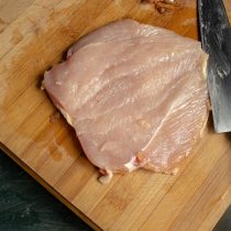 Острым ножом прорезаем куриное филе вдоль и разворачиваем