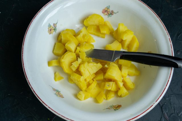 Сваренный картофель нарезаем кубиками и кладём в салатник