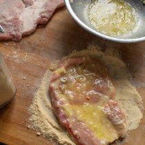 Обмакиваем шницели в яйцо с луком, после панируем в молотых сухарях
