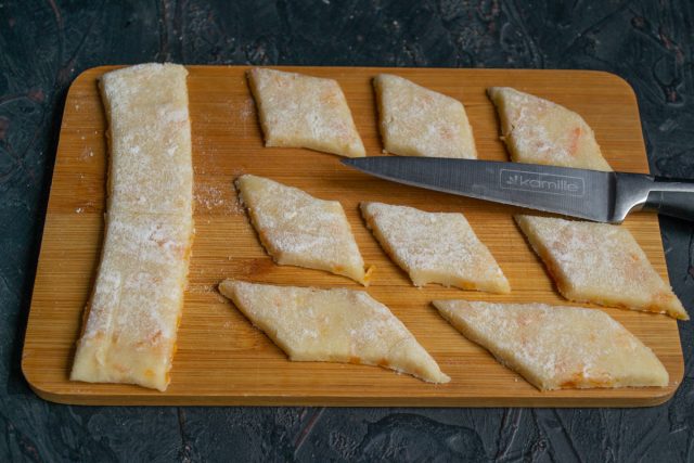 Нарезаем раскатанное тесто широкими полосами, полосы нарезаем ромбами Нарезаем раскатанное тесто широкими полосами, полосы нарезаем ромбами