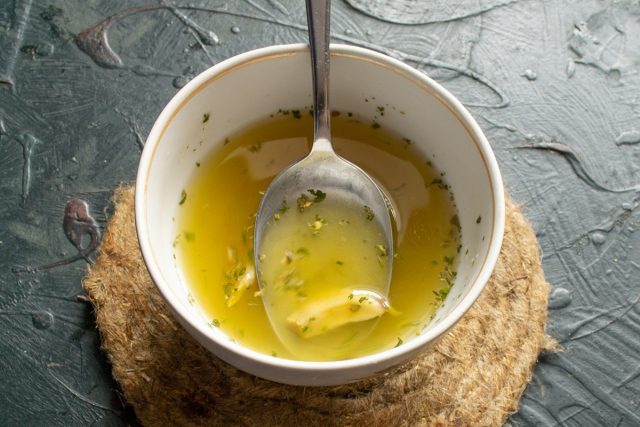 Смешиваем бульон с сушеной петрушкой и нарезанными зубчиками чеснока