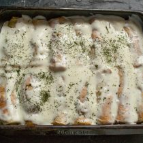Заливаем блины горячим молочным соусом, посыпаем сушеным укропом и запекаем 