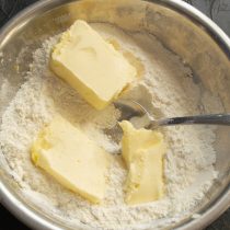Холодное сливочное масло режем кубиками, добавляем в миску