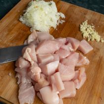 Нарезаем филе и репчатый лук, дольки чеснока пропускаем через пресс