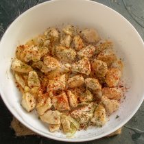 На дно формы выкладываем обжаренную курицу, посыпаем приправами