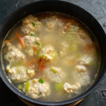 Рыбный бульон с овощами солим по вкусу. Кладём в еле-еле кипящий бульон фрикадельки