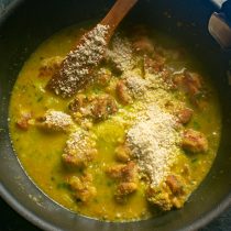 Вливаем куриный бульон. Насыпаем молотый арахис. Солим по вкусу, нагреваем до кипения