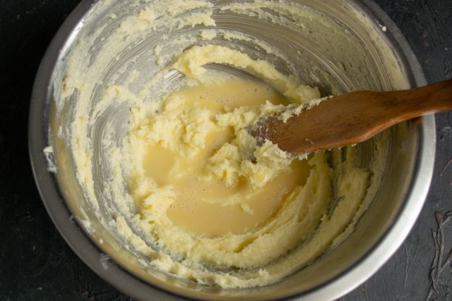 Насыпаем в миску белый сахар, добавляем порезанное кубиками сливочное масло. Растираем масло с сахаром, добавляем половину большого куриного яйца