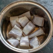 Подготовленную рыбу нарезаем толстыми кусочками, кладём в суповую кастрюлю