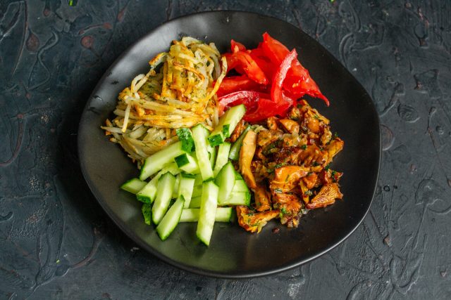 Кладём рядом с грибами и помидорами горки из огурцов и жаренной картошки.