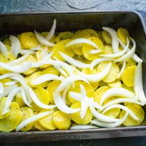 Репчатый лук нарезаем узкими дольками. Достаем подпеченный картофель из духовки