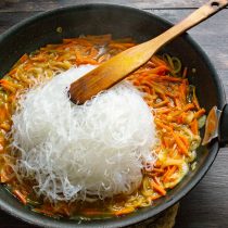 Кладем в сковороду фунчозу. Смешиваем вермишель с овощами и бульоном Кладем в сковороду фунчозу. Смешиваем вермишель с овощами и бульоном