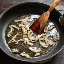 Копченый бекон с прослойками мяса нарезаем узкими тонкими полосками