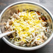 Добавляем в салат сваренные вкрутую куриные яйца. Можно натереть яйца на терке