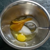 Насыпаем в глубокую миску мелкий белый сахар. Разбиваем крупное куриное яйцо.