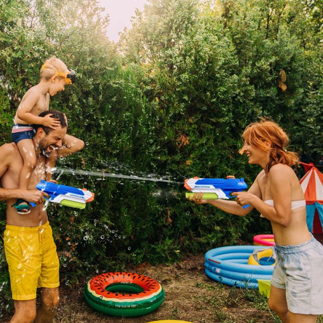 Семья играет с водными пистолетами
