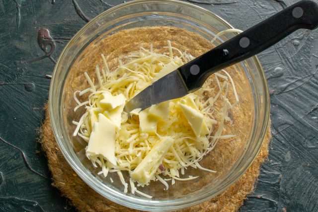 Нарезаем кубиками размягченное сливочное масло, добавляем к сыру и чесноку. Нарезаем кубиками размягченное сливочное масло, добавляем к сыру и чесноку.