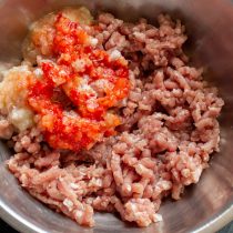 Кладём в мясорубку половину небольшой луковицы и половину красного сладкого перца Кладём в мясорубку половину небольшой луковицы и половину красного сладкого перца