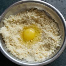 Делаем углубление в масляной крошке, разбиваем крупное куриное яйцо Делаем углубление в масляной крошке, разбиваем крупное куриное яйцо