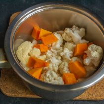 Кладём нарезанные овощи в сотейник, вливаем кипяток, солим по вкусу