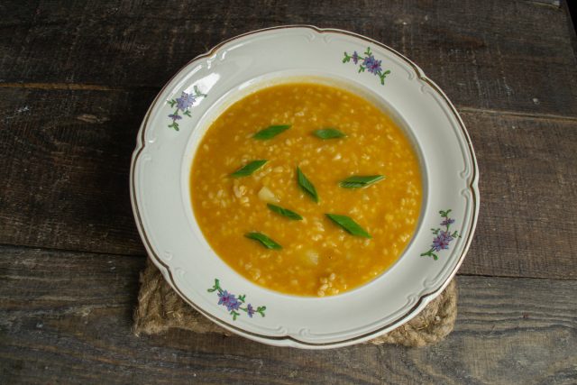 Подаём рисовый суп с курицей, булгуром и картошкой на стол горячим, посыпаем зелёным лучком или укропом